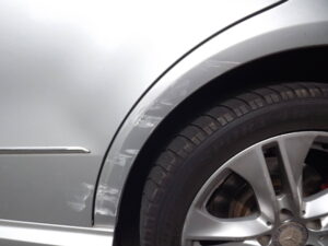 Beschädigter Kotflügel an einem Fahrzeug nach einem Parkschaden